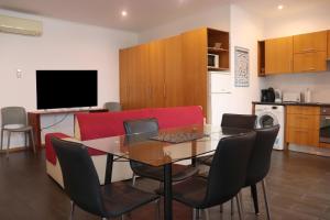 a living room with a table and chairs and a television at Faial Marina Apartments 1 in Horta