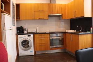 a kitchen with a washing machine and a washer at Faial Marina Apartments 1 in Horta