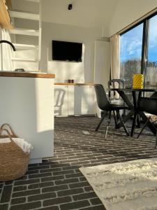 a living room with a table and chairs and a kitchen at The Conservatory, a cosy holiday home located central between Gent Antwerpen & Brussel in Lokeren