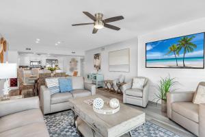 a living room with white furniture and a ceiling fan at 201 Surfside in Clearwater Beach