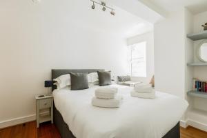 a bedroom with a large white bed with white pillows at A Wave From It All - Extensive Harbour Views from Wrap-Around Balcony in Poole