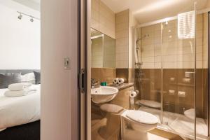 a bathroom with a toilet a sink and a shower at A Wave From It All - Extensive Harbour Views from Wrap-Around Balcony in Poole
