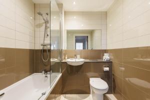 a bathroom with a toilet and a sink and a shower at A Wave From It All - Extensive Harbour Views from Wrap-Around Balcony in Poole +24 photos