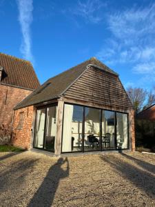 an extension to a house with large glass windows at The Conservatory, a cosy holiday home located central between Gent Antwerpen & Brussel in Lokeren