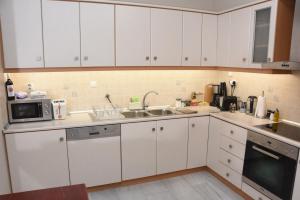 a kitchen with white cabinets and a sink and a microwave at Sparta Central Apartment with Free Parking in Sparta