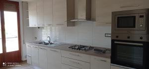 a kitchen with a sink and a stove and a microwave at Casa Serena in Carrara +16 photos