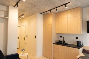 a kitchen with wooden cabinets and a living room at Echoes of Thrace in Xanthi +91 photos