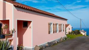 a white house with a view of the ocean at Faial Cottage in Cedros