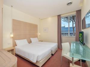 a hotel room with a bed and a glass table at B&B HOTEL Calenzano First in Calenzano