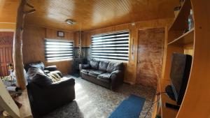 a living room with a couch and a television at Cabaña con tinaja Aucaco in Ancud