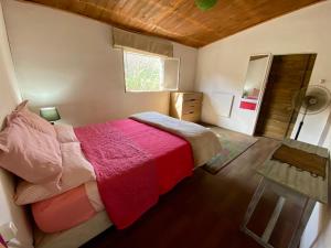 a bedroom with a bed with a red blanket and a window at Lagomar Casa tipo loft in Ciudad de la Costa