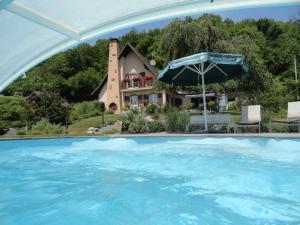 a house with a swimming pool in front of a house at GÏTE LA DANSE DES BICHES in Ranspach +8 photos