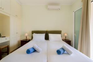 a bedroom with a white bed with blue pillows at Villa Nefeli Breeze in Dassia +27 photos