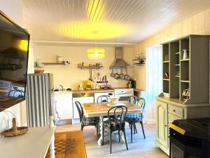 a kitchen with a table and chairs in it at La p'tite Maison in Vitrac +13 photos