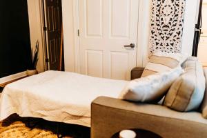 a room with a bed and a couch and a door at Sol Sage Studio Downtown in Wilmington