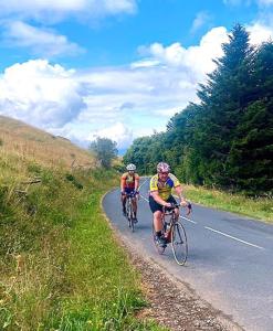two people riding bikes down a road at La p'tite Maison in Vitrac