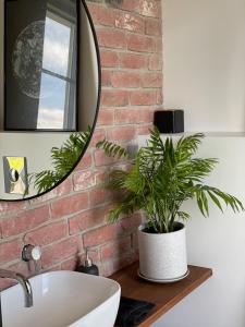 a bathroom with a white sink and a brick wall at Nice getaway, 20 min from Tallinn in Järsi +28 photos