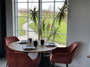 a table and chairs with a table and a window at Nice getaway, 20 min from Tallinn in Järsi