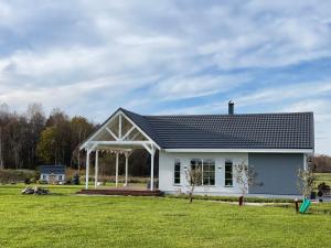 a white house with a gambrel roof at Nice getaway, 20 min from Tallinn in Järsi