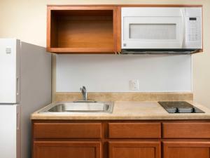 
a kitchen with a sink and a microwave at WoodSpring Suites Dickinson in Dickinson
