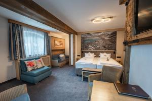 a hotel room with a bed and a table and chairs at Hotel Eder Michaela in Saalbach-Hinterglemm