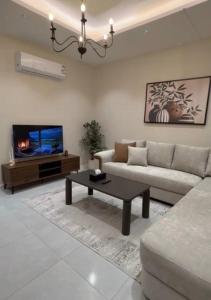 a living room with a couch and a tv at Riwaq suite in Jeddah