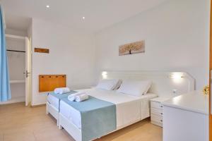 a white bedroom with a bed with towels on it at Beachside Bungalows Acharavi Corfu in Acharavi +109 photos