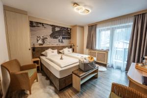 a hotel room with a bed and a large window at Hotel Eder Michaela in Saalbach-Hinterglemm