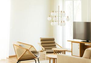 a living room with chairs and a television at B&O Parkhotel in Bad Aibling
