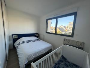 a small bedroom with a bed and a window at Les cabines de Granville in Granville