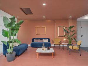 a living room with a blue couch and chairs at B&B HOTEL Calenzano First in Calenzano