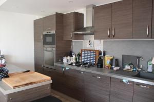 a kitchen with wooden cabinets and a counter top at Les cabines de Granville in Granville