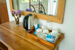 a wooden shelf with water bottles and a mirror at Evergreen Villa - Sinharaja in Deniyaya +285 photos