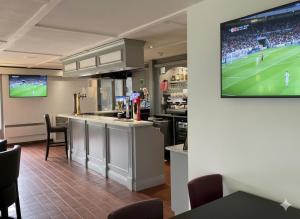 a kitchen with a football game on a tv at The Galleon Hotel, Hull City, Part of the AG Collection in Hull