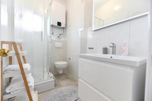 a white bathroom with a sink and a toilet at Apartments Martom in Seline +82 photos