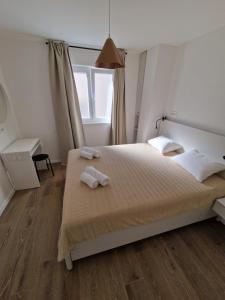 a bedroom with a bed with two towels on it at Apartmani Tribunj Cvitan in Tribunj