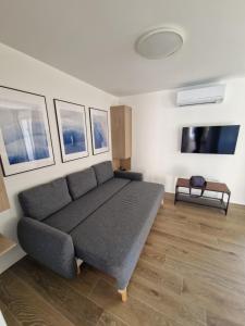 a living room with a couch and a tv at Apartmani Tribunj Cvitan in Tribunj