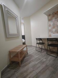 a room with a bench and a table and chairs at JQC Rooms in Madrid