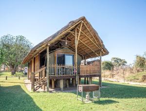 eine kleine Hütte mit Strohdach auf einem Feld in der Unterkunft Mwandi View in Kavimba