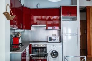 a kitchen with red cabinets and a white refrigerator at Piso en Antigua Casa de Correos in Molina de Aragón