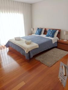 a bedroom with a large bed with blue pillows at Casa do Sol - Entre o Mar e o Pinhal in Apúlia +66 photos