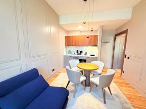 a living room with a blue couch and a table and chairs at Amaroo - Boarding & Serviced Apartments "Regia" in Potsdam
