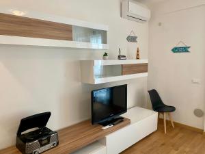 ein Wohnzimmer mit Fernseher und zwei Sesseln in der Unterkunft Paper House in Rom