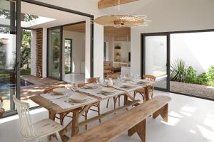 a dining room with a wooden table and chairs at CLUQUE- Maisons de Vacances in Capbreton