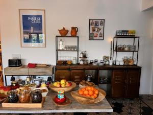 a kitchen with many baskets of fruit on a table at LES VOLETS ROUGES - Hôtel Cassis - Situé dans le Parc National des Calanques - Parking Gratuit in Cassis