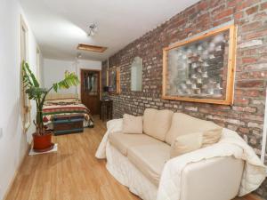 a living room with a brick wall and a couch at The Toolshed in Warrington