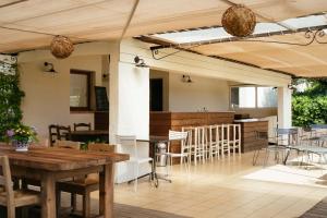 a patio with a table and chairs and a kitchen at Les Hauts de Santa Giulia in Porto-Vecchio