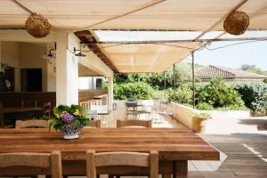 a wooden table with a vase of flowers on a patio at Les Hauts de Santa Giulia in Porto-Vecchio +54 photos