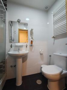 a bathroom with a sink and a toilet and a mirror at JQC Rooms in Madrid +47 photos