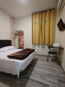 a bedroom with a bed and a table and curtains at JQC Rooms in Madrid